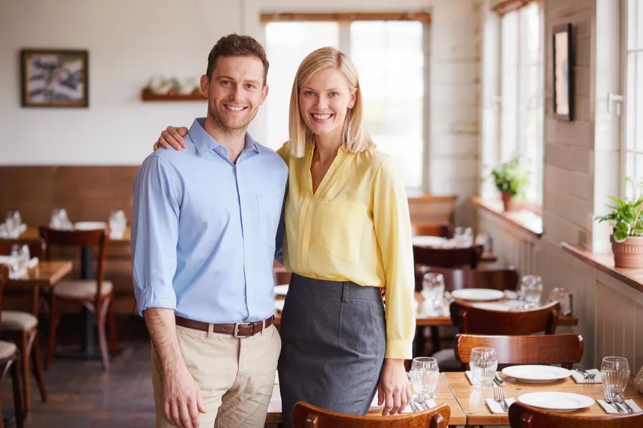 Restaurant owner and manager in a dining room, multi-location restaurant marketing